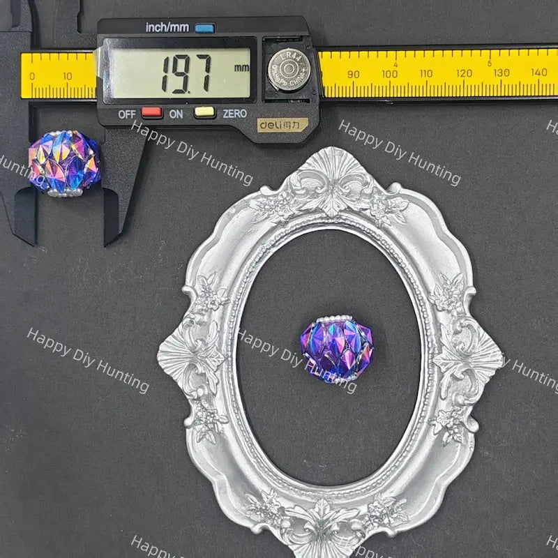 A purple iridescent oval bead shown with a silver ornate frame and a digital caliper measuring 19.7 mm, on a dark gray background with a repeating 'Happy DIY Hunting' watermark.