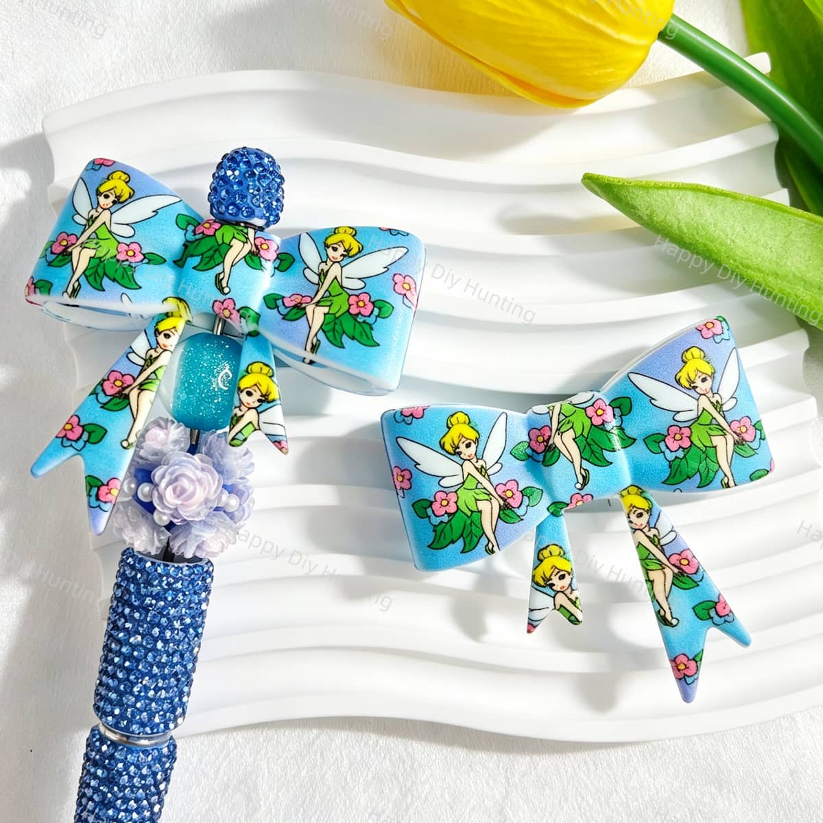 Bow-shaped silicone focal beads featuring a blue winged fairy girl and floral print design. Soft, durable, and flexible, perfect for beadable pens, keychains, and handmade crafts.