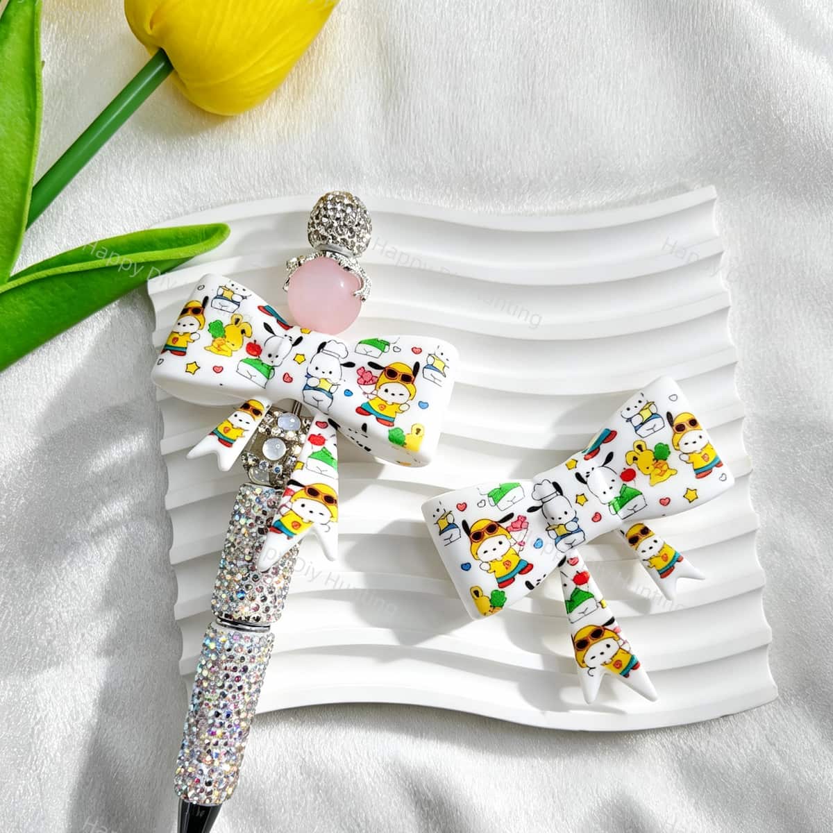 White bow-shaped silicone focal beads with colorful cartoon dog designs, including dogs wearing sunglasses, chef hats, and bow ties. Shown with a rhinestone beadable pen and a pink round bead. Perfect for beadable pens, keychains, and handmade crafts.
