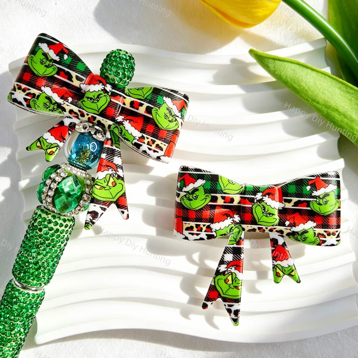 Bow-shaped silicone focal beads featuring a Christmas green character wearing a Santa hat print design. Soft, durable, and flexible, perfect for beadable pens, keychains, and handmade holiday crafts.