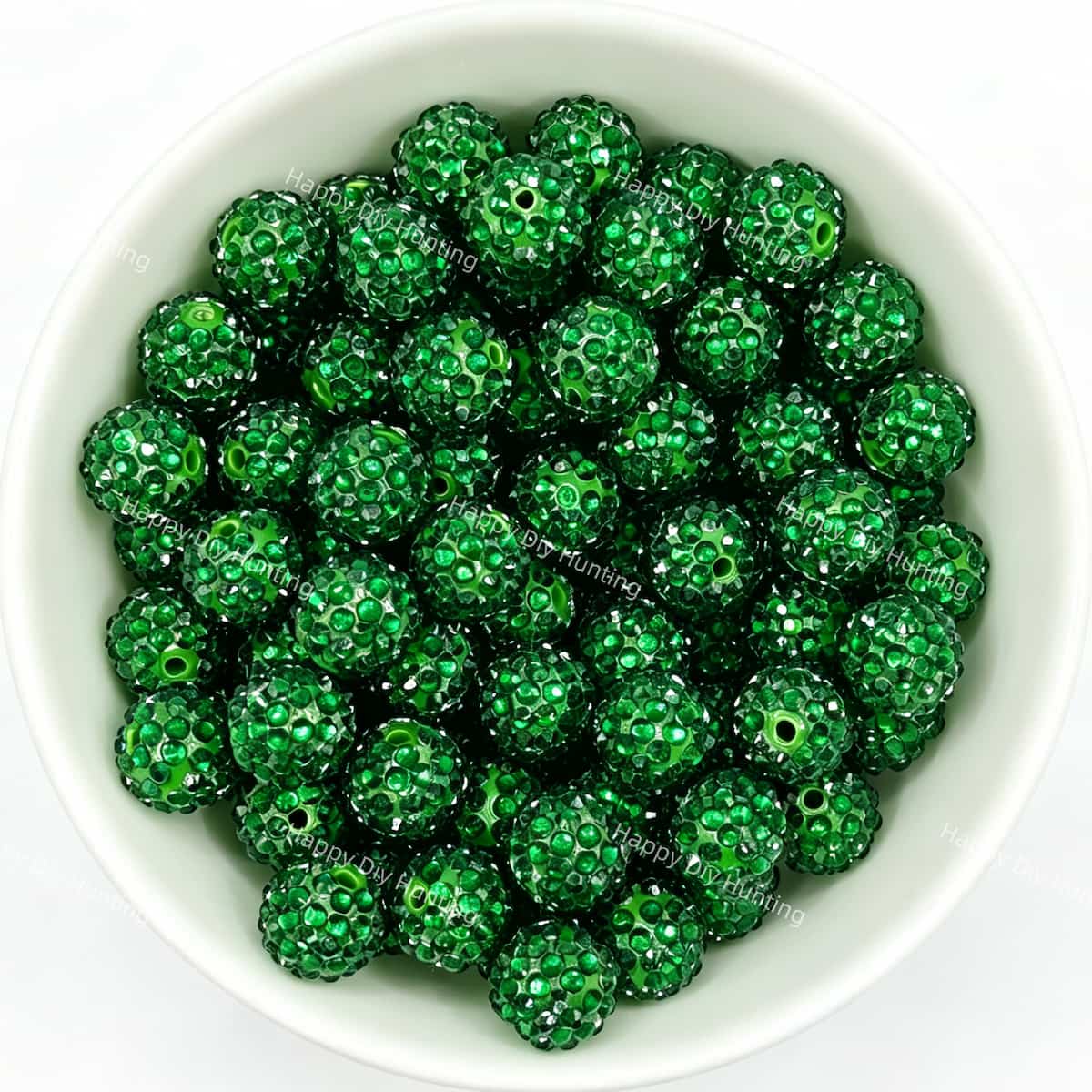 Dark green rhinestone beads in matte white bowl, white background, top‑down view, high‑resolution product photo