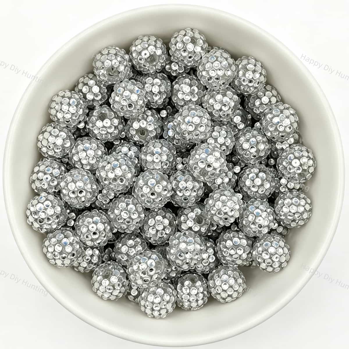 Silver rhinestone beads in matte white bowl, white background, top‑down view, high‑resolution product photo