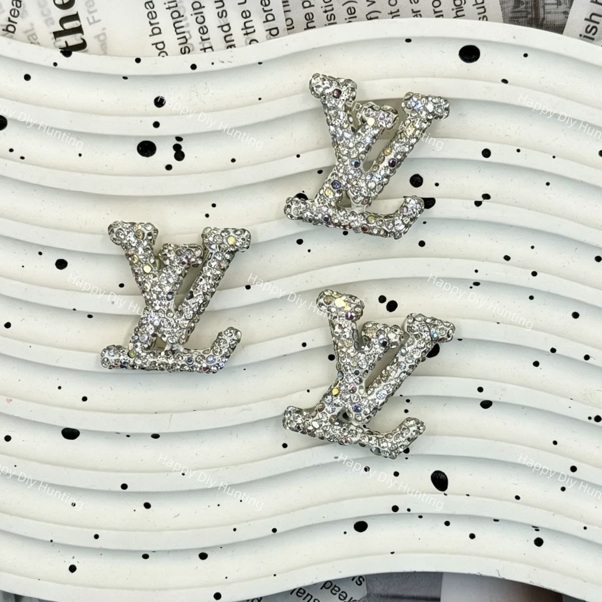 Silver tone AB iridescent rhinestone LV charm for handmade jewelry and cream glue projects.