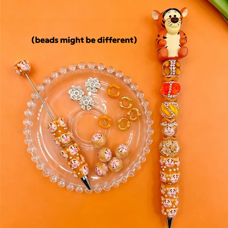 Tigger theme DIY beadable pen crafts with an orange tiger pen topper, patterned focal beads, and sparkling crystal rhinestone details.