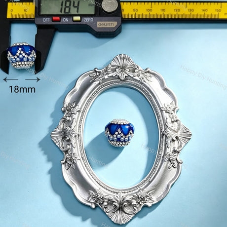 18mm dark blue crown-shaped bead decorated with pearls and sparkling rhinestones. Elegant and shiny, perfect for beadable pens, keychains, and handmade crafts.