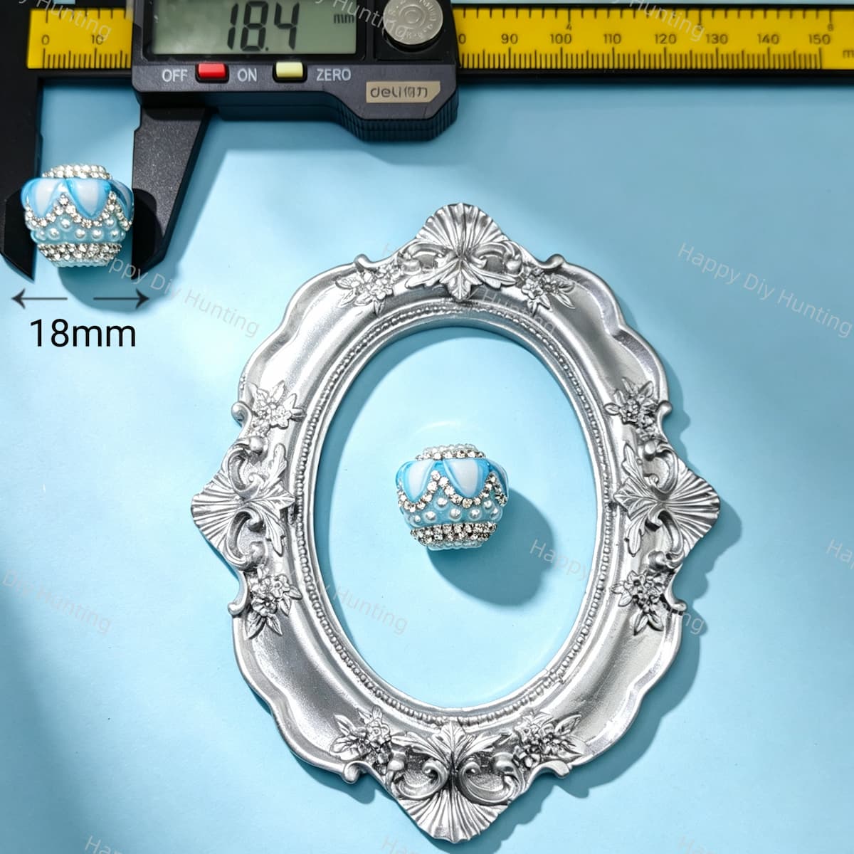 18mm light blue crown-shaped bead decorated with pearls and sparkling rhinestones. Elegant and shiny, perfect for beadable pens, keychains, and handmade crafts.