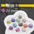 Twelve faceted round craft beads in various iridescent colors, displayed on a white cloud-shaped tray. A digital caliper is shown on the left measuring one bead to 19.