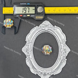 A small oval faceted iridescent crystal bead is shown with a silver ornate frame and a digital caliper above it on a dark gray background. The caliper scale is marked in inches and millimeters, and the image includes repeated 'Happy DIY Hunting' watermarks.