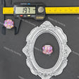 A silver oval decorative frame displayed on a dark gray background, with a small iridescent pink-purple crystal bead placed inside the frame. A digital caliper and yellow measuring tape are shown above to indicate size.