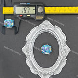 An ornate silver oval picture frame displayed on a dark gray background, with a small iridescent blue-purple crystal bead shown inside the frame. A digital caliper is positioned above the frame to show measurements, and the brand name Happy DIY Hunting is watermarked across the image.