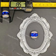 A blue and clear rhinestone ring displayed on an ornate silver oval frame, with a caliper at the top showing 19.5 mm measurements and a small ring on a black stand at the upper left.