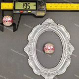 A pink and clear rhinestone oval bead shown with a silver ornate frame, a caliper, and a digital caliper ruler on a dark gray background with 'Happy DIY Hunting' watermarks.