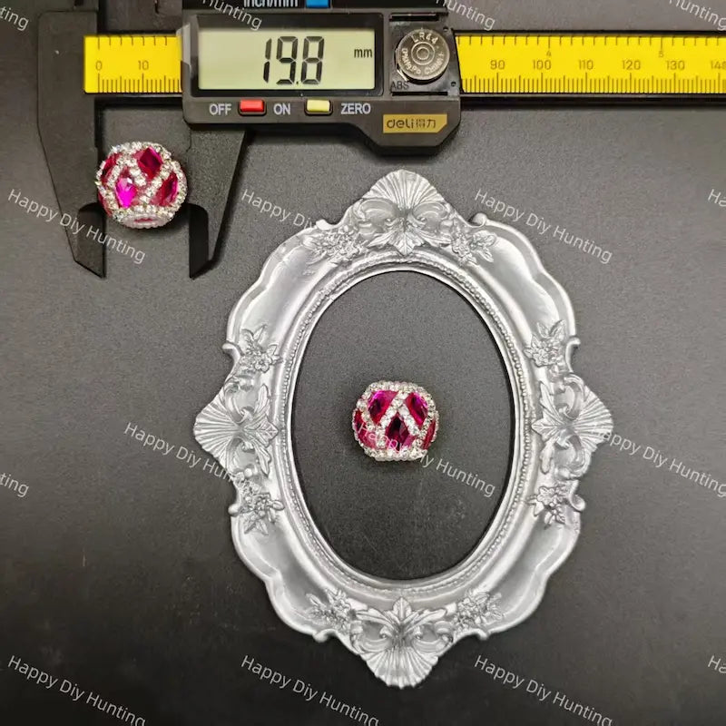 A single round gemstone jewelry piece displayed on a black surface, with a silver ornate frame and a caliper above it showing a 19.8 mm measurement.