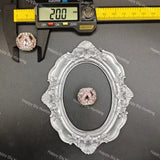 A pink rhinestone cabochon gemstone displayed on a black background, with a silver ornate oval frame and a digital caliper showing 20.0 mm measurements above it.