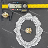 A small oval silver frame displayed on a dark gray background, with a yellow caliper above it showing 19.7 mm measurements and a gold-and-white beaded ornament placed inside the frame for scale.