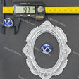 A decorative oval silver frame with floral detailing, shown on a dark gray background alongside a blue and white beaded ornament and a caliper measuring 19.7 mm.