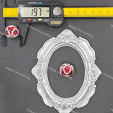 A small red and white beaded jewelry charm is shown on a dark gray background with a silver ornate oval frame, a digital caliper reading 19.7 mm, and a yellow inch/mm ruler.
