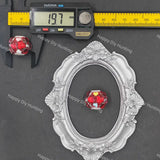 An ornate oval silver picture frame displayed on a dark gray surface, with a red and white marbled bead placed inside the frame. A Caliber digital caliper is shown at the top left to indicate the frame's width as 19.