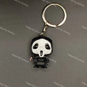 A keychain featuring a stylized, cartoonish figure with a black and white mask, black robe, and silver metal key ring and chain, shown on a dark gray background with repeating 'Happy DIY Hunting' watermarks.