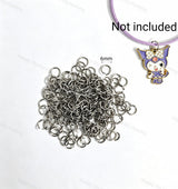 6mm silver open jump rings made of sturdy metal with a smooth finish. Perfect for connecting charms, beads, and pendants in DIY jewelry making and handmade crafts.