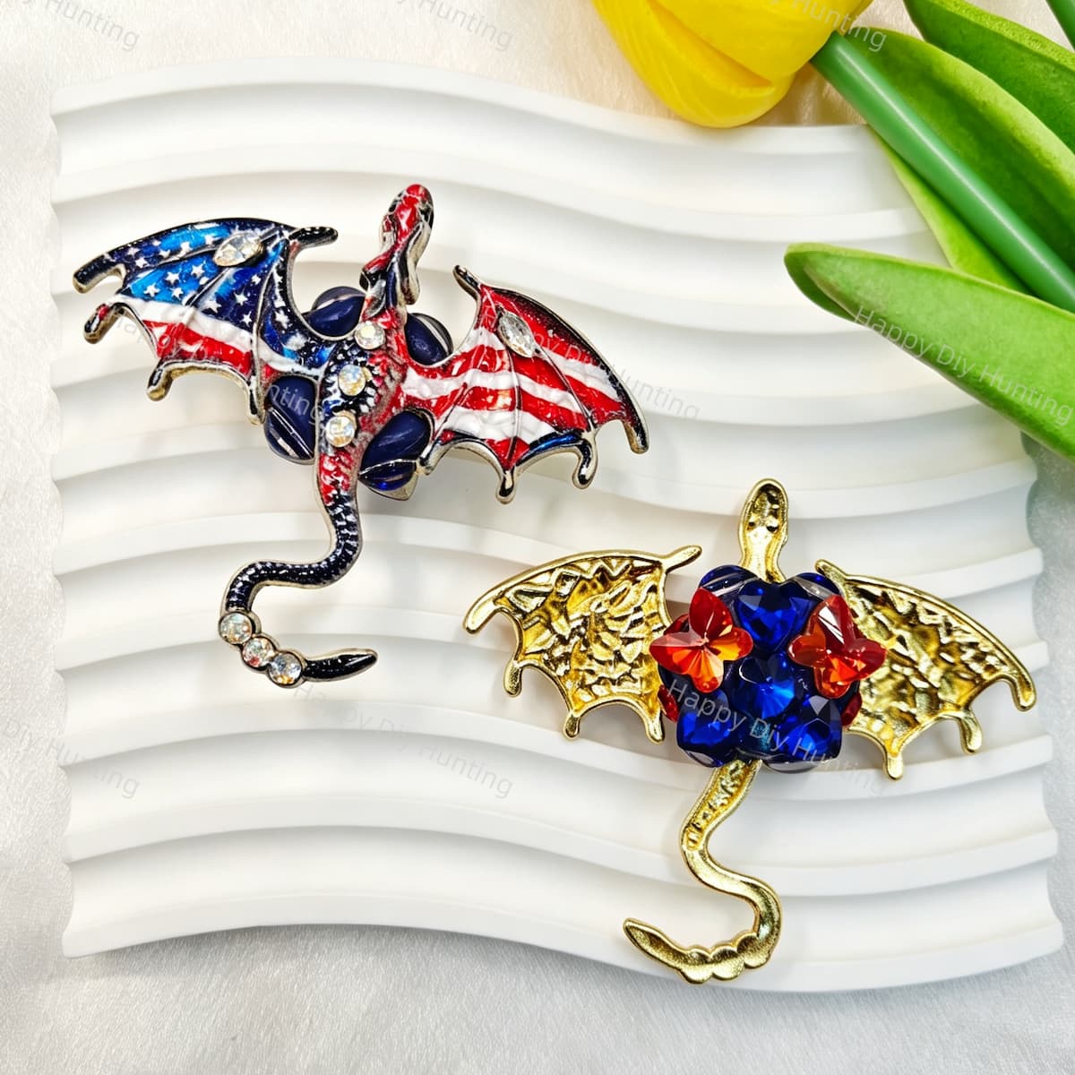 	American flag flying winged dragon metal fancy bead with rhinestones shown from the front and back. The front features a patriotic red, white, and blue dragon with enamel wings and a rhinestone-studded body, while the back shows gold metal wings with a blue crystal flower center. Perfect for DIY beadable pens and crafts.