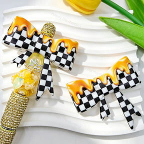 Silicone bow beads featuring a black and white checkered pattern with a glossy honey drip finish. Soft, durable, and flexible, perfect for beadable pens, keychains, and handmade crafts.