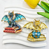 Blue and red book winged dragon metal fancy beads with rhinestones shown from the front and back. The front features a detailed dragon with colorful enamel wings sitting on red books, while the back shows a gold metal finish. Perfect for DIY beadable pens and crafts.