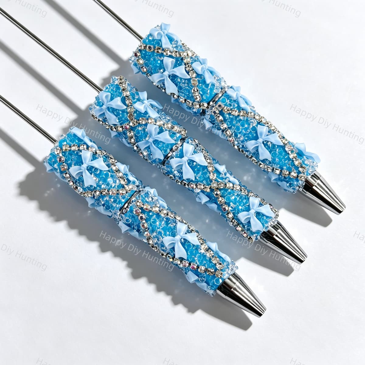 Blue beadable pen featuring a decorative bow and sparkling rhinestones. Refillable and customizable, perfect for DIY crafts and handmade gifts.
