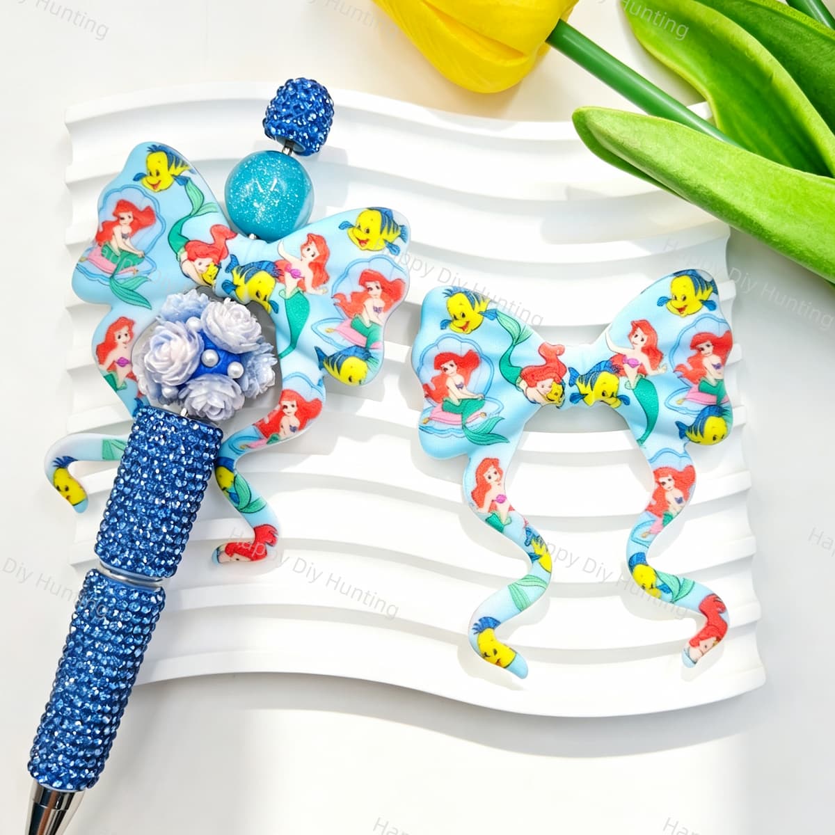 Bow-shaped silicone focal beads featuring a blue mermaid princess and fish print design. Soft, durable, and flexible, perfect for beadable pens, keychains, and handmade crafts.