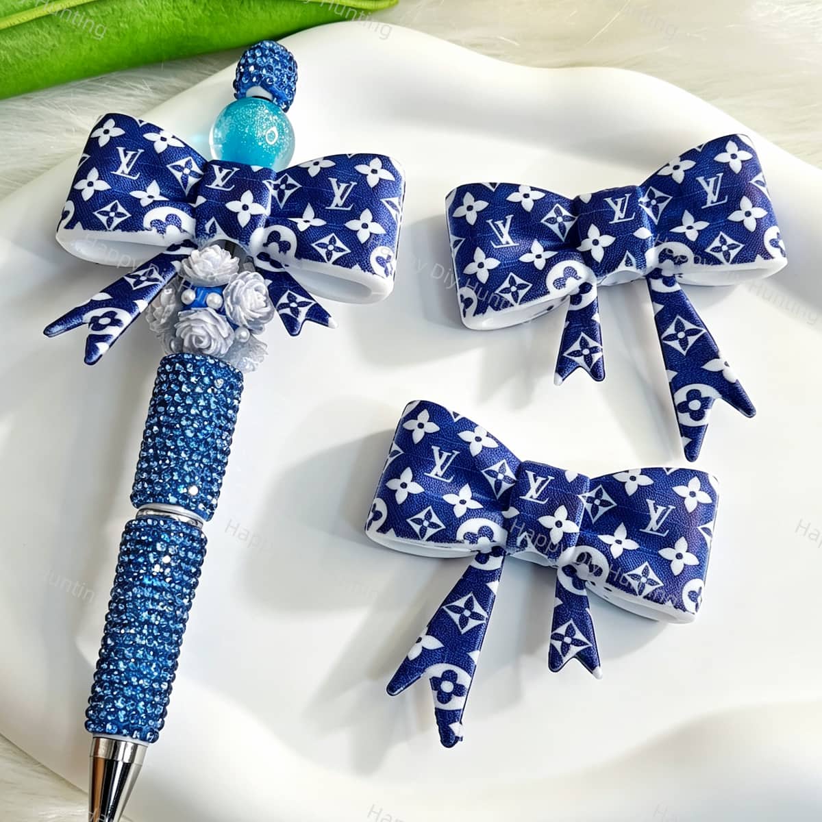 Bow-shaped silicone focal beads featuring a blue and white cute monogram print design. Soft, durable, and flexible, perfect for beadable pens, keychains, and handmade crafts.