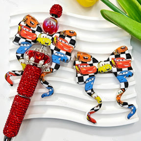 Bow-shaped silicone focal beads featuring a cartoon car and checkered print design. Soft, durable, and flexible, perfect for beadable pens, keychains, and handmade crafts.