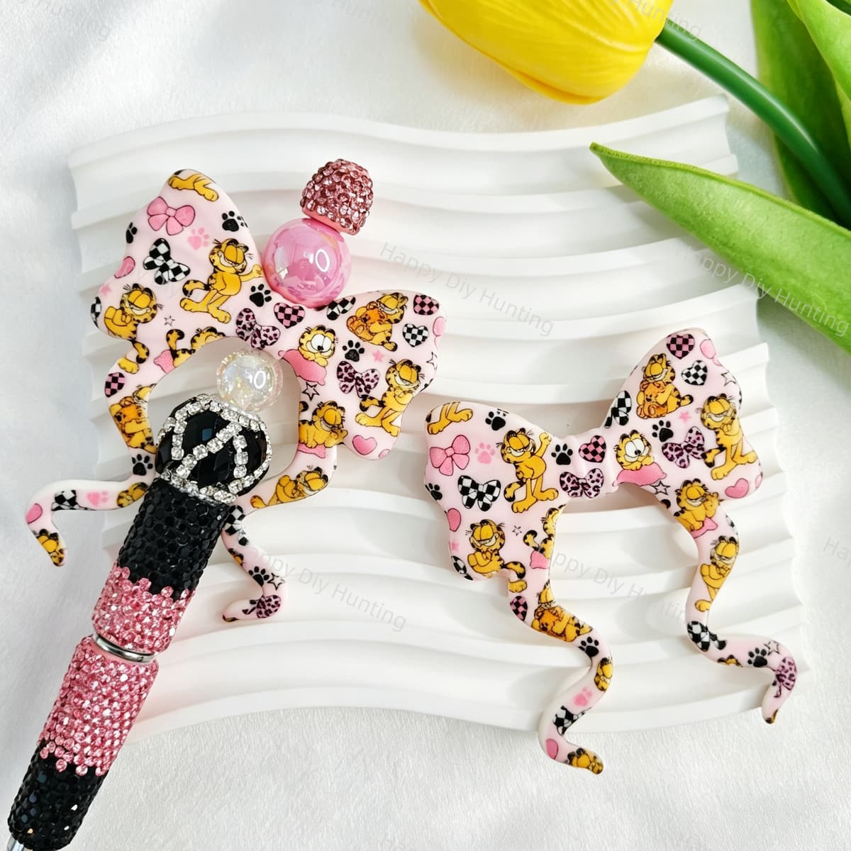 Bow-shaped silicone focal beads featuring a cute cartoon orange cat print design. Soft, durable, and flexible, perfect for beadable pens, keychains, and handmade crafts.