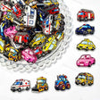 A large mixed pile of colorful cartoon vehicle print acrylic focal beads. Designs include ambulances, fire trucks, police cars, taxis, school buses, tractors, and pink cars in bright colors. Perfect for beadable pens, keychains, and jewelry making.