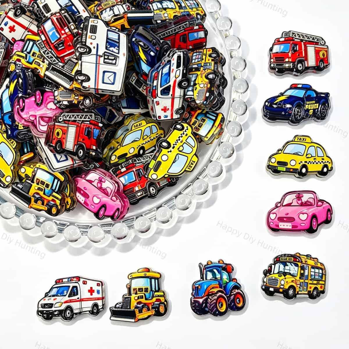 A large mixed pile of colorful cartoon vehicle print acrylic focal beads. Designs include ambulances, fire trucks, police cars, taxis, school buses, tractors, and pink cars in bright colors. Perfect for beadable pens, keychains, and jewelry making.
