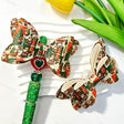 Bow-shaped beads featuring a Christmas Santa Claus print design. Lightweight, festive, and durable, perfect for beadable pens, keychains, and handmade holiday crafts.