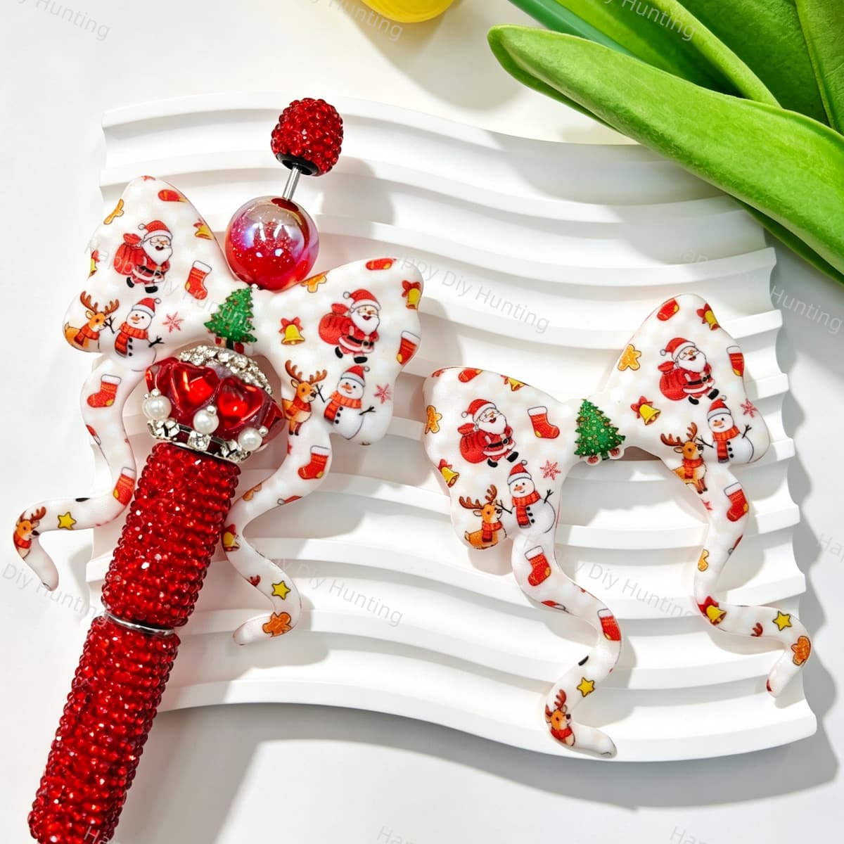 Bow-shaped silicone focal beads featuring a festive Christmas Santa, snowman, and reindeer print design. Soft, durable, and flexible, perfect for beadable pens, keychains, and handmade holiday crafts.