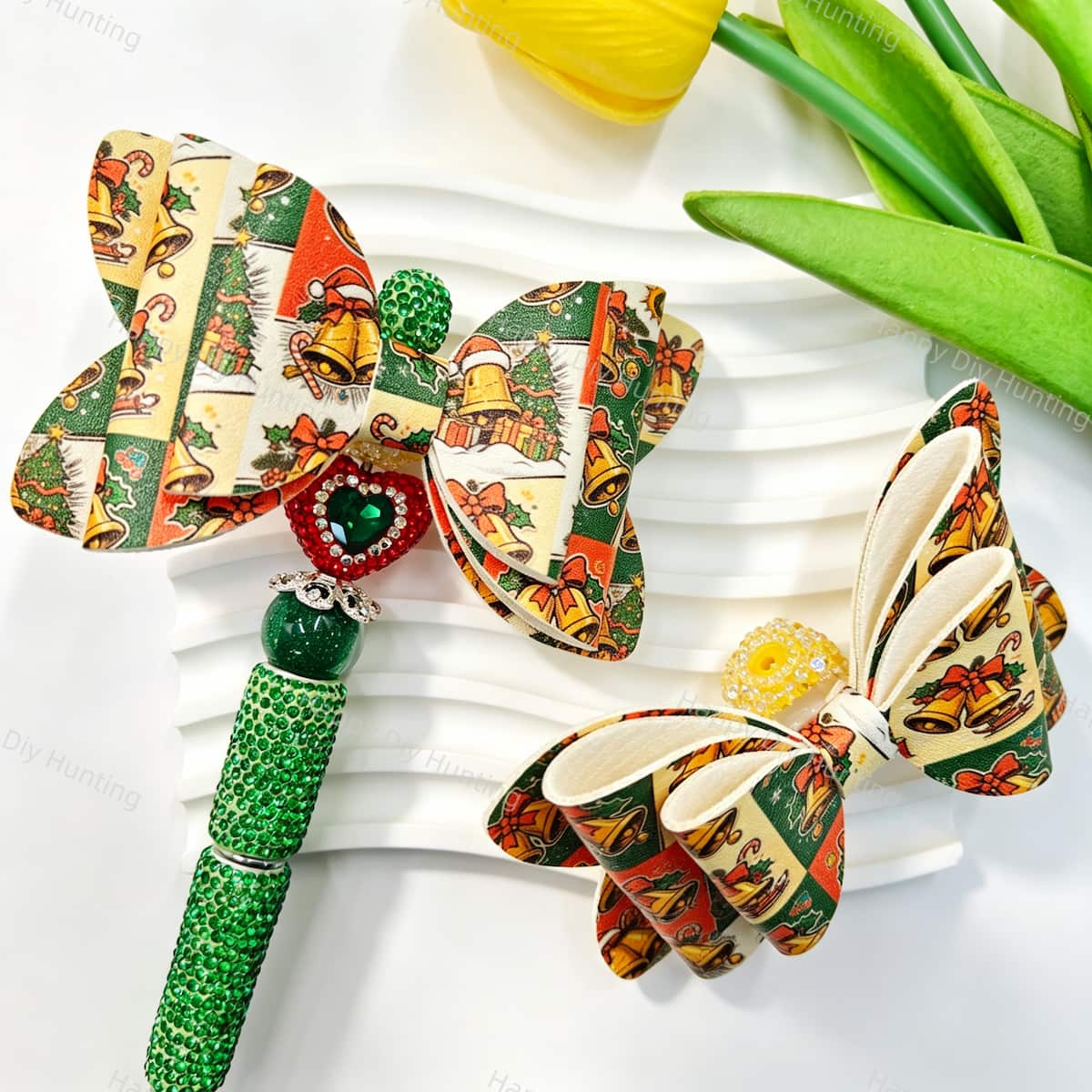 Bow-shaped beads featuring a Christmas bell print design. Lightweight, festive, and durable, perfect for beadable pens, keychains, and handmade holiday crafts.