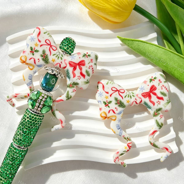Bow-shaped silicone focal beads featuring a festive Christmas pine, snowflake, and candy ribbon print design. Soft, durable, and flexible, perfect for beadable pens, keychains, and handmade holiday crafts.