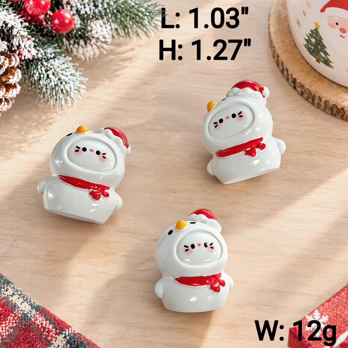 A Christmas cartoon kitty clay pen topper featuring a white snowman outfit with a red Santa hat and scarf. Measures 1.03" L x 1.27" H and weighs 12g. Solid clay topper with no pre-drilled holes, perfect for custom beadable pens and DIY crafts.
