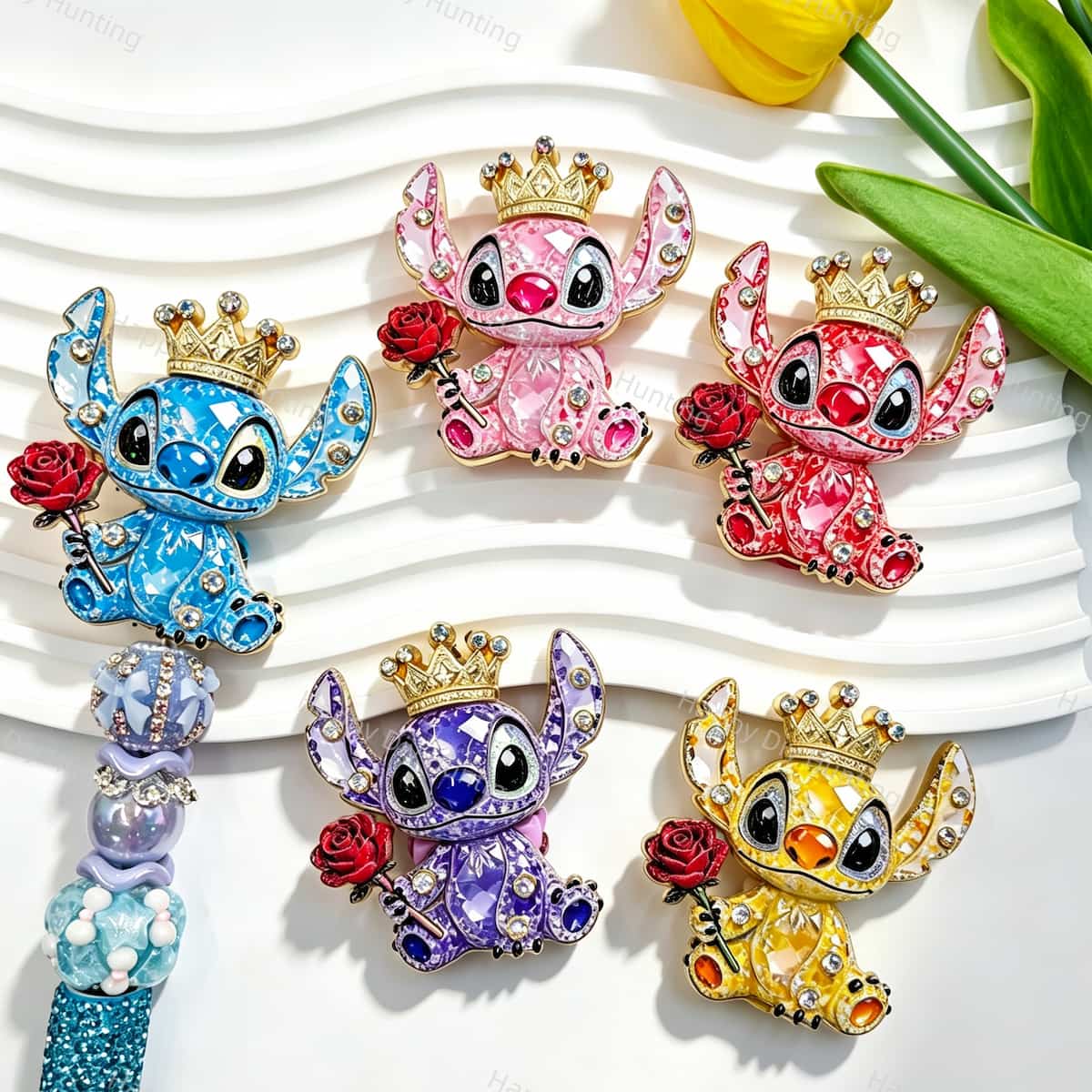 Five crown alien metal fancy beads with rhinestones displayed on a white wavy tray. Colors include blue, pink, red, purple, and yellow, each holding a red rose with a gold crown. Perfect for DIY beadable pens, keychains, and handmade crafts.