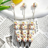 Three cute cartoon elephant character beadable pens displayed on a newspaper background. Each pen features white beads decorated with pink cartoon elephant faces wearing purple collars, plus clear rhinestones and silver metal tips. Perfect for DIY crafts, focal beads, and handmade gifts.