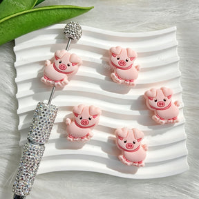 Silicone focal beads featuring a cute pink pig cartoon design. Soft, durable, and flexible, perfect for beadable pens, keychains, and handmade crafts.