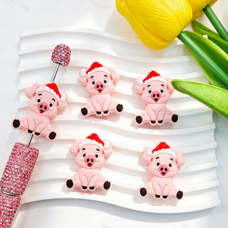 Silicone focal beads featuring a cute pink pig wearing a Santa hat. Soft, durable, and flexible, perfect for beadable pens, keychains, and handmade holiday crafts.