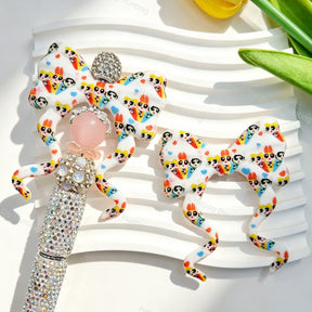 Bow-shaped silicone focal beads featuring a cute superhero girls cartoon print design. Soft, durable, and flexible, perfect for beadable pens, keychains, and handmade crafts.
