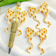 Bow-shaped silicone focal beads featuring a cute yellow bear cartoon design. Soft, durable, and flexible, perfect for beadable pens, keychains, and handmade crafts.