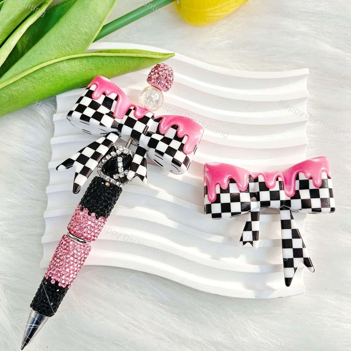 Bow-shaped silicone focal beads featuring a pink checkerboard pattern with a glossy drip finish. Soft, durable, and flexible, perfect for beadable pens, keychains, and handmade crafts.