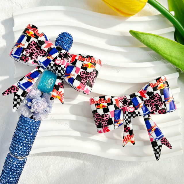 Bow-shaped silicone focal beads featuring an energy drink can print design. Soft, durable, and flexible, perfect for beadable pens, keychains, and handmade crafts.