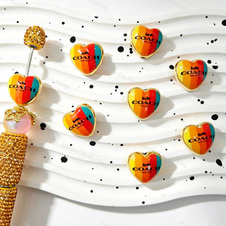 Acrylic beads featuring a rainbow heart design with gold trim. Lightweight, durable, and colorful, perfect for beadable pens, jewelry making, and handmade crafts.