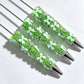 Green beadable pen featuring a decorative bow and sparkling rhinestones. Refillable and customizable, perfect for DIY crafts and handmade gifts.