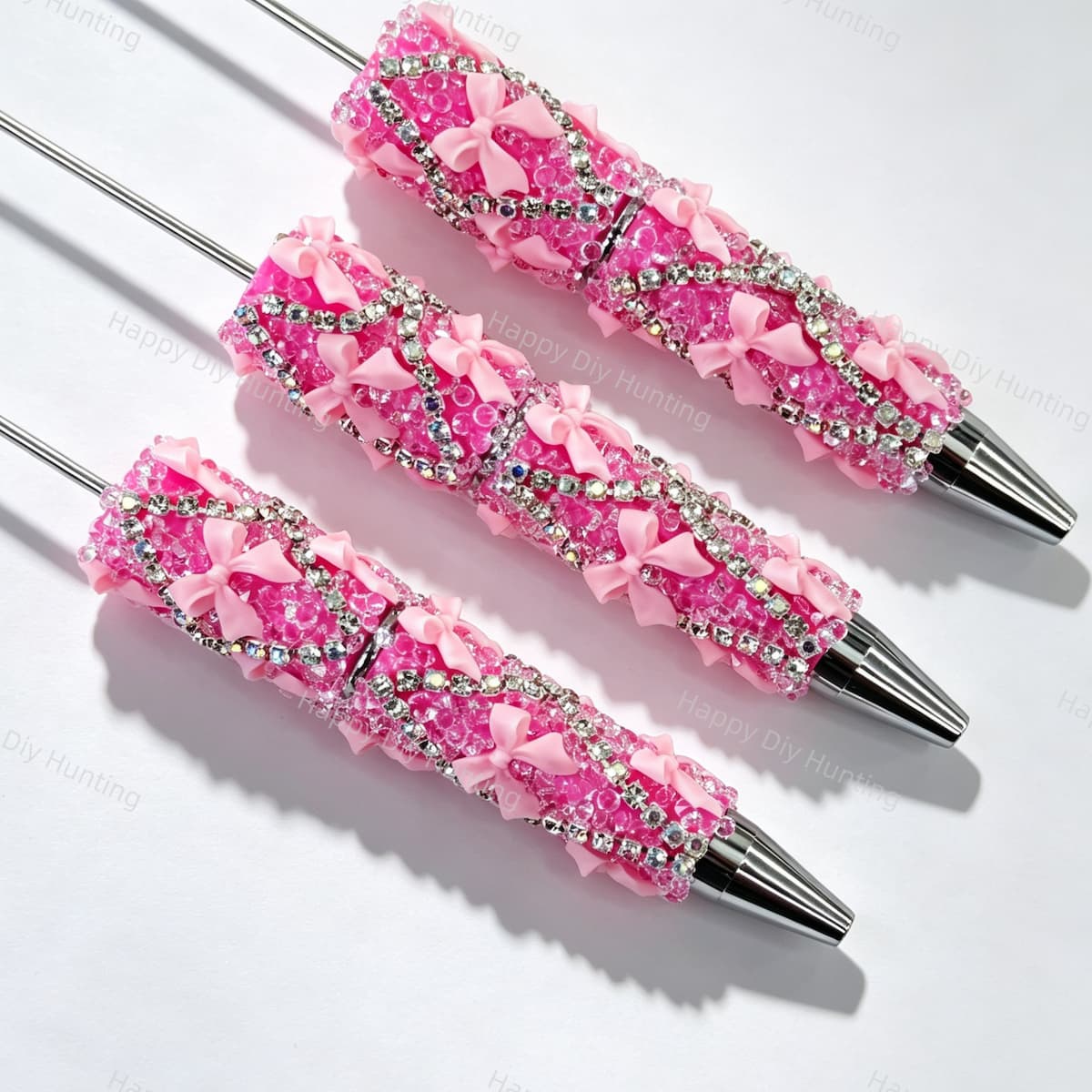 Hot pink beadable pen featuring a decorative bow and sparkling rhinestones. Refillable and customizable, perfect for DIY crafts and handmade gifts.